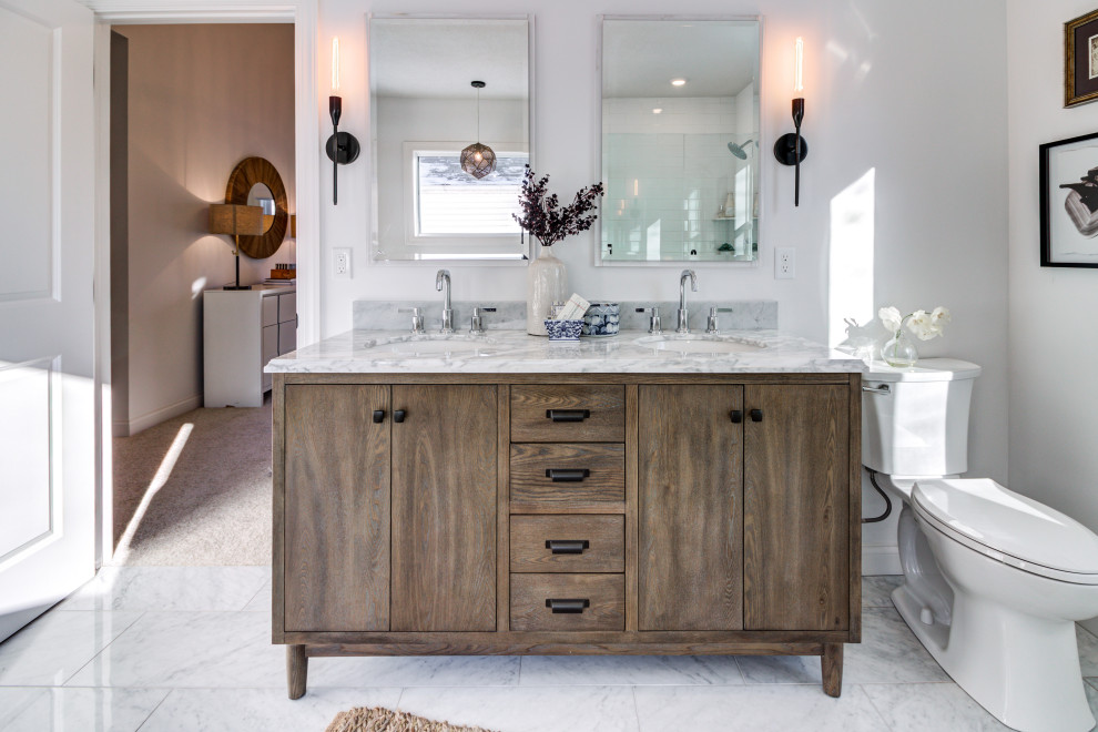 Aménagement d'une salle de bain classique en bois vieilli avec un placard à porte plane, un mur blanc, un plan de toilette en marbre, un plan de toilette blanc, meuble double vasque et meuble-lavabo sur pied.