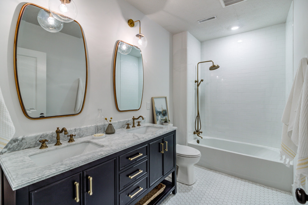 Exempel på ett klassiskt vit vitt badrum, med blå skåp, ett badkar i en alkov, vit kakel, tunnelbanekakel, vita väggar, klinkergolv i keramik, ett undermonterad handfat, marmorbänkskiva, vitt golv och luckor med infälld panel