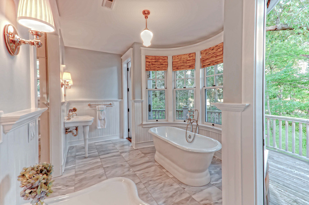 Foto di una grande stanza da bagno padronale classica con vasca freestanding, pareti arancioni, lavabo a consolle, pavimento in marmo e pavimento grigio