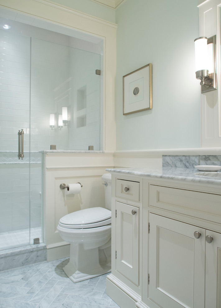 Alcove shower - small traditional 3/4 white tile and subway tile marble floor and gray floor alcove shower idea in Charleston with blue walls, recessed-panel cabinets, white cabinets, a two-piece toilet, an undermount sink, marble countertops, gray countertops and a hinged shower door