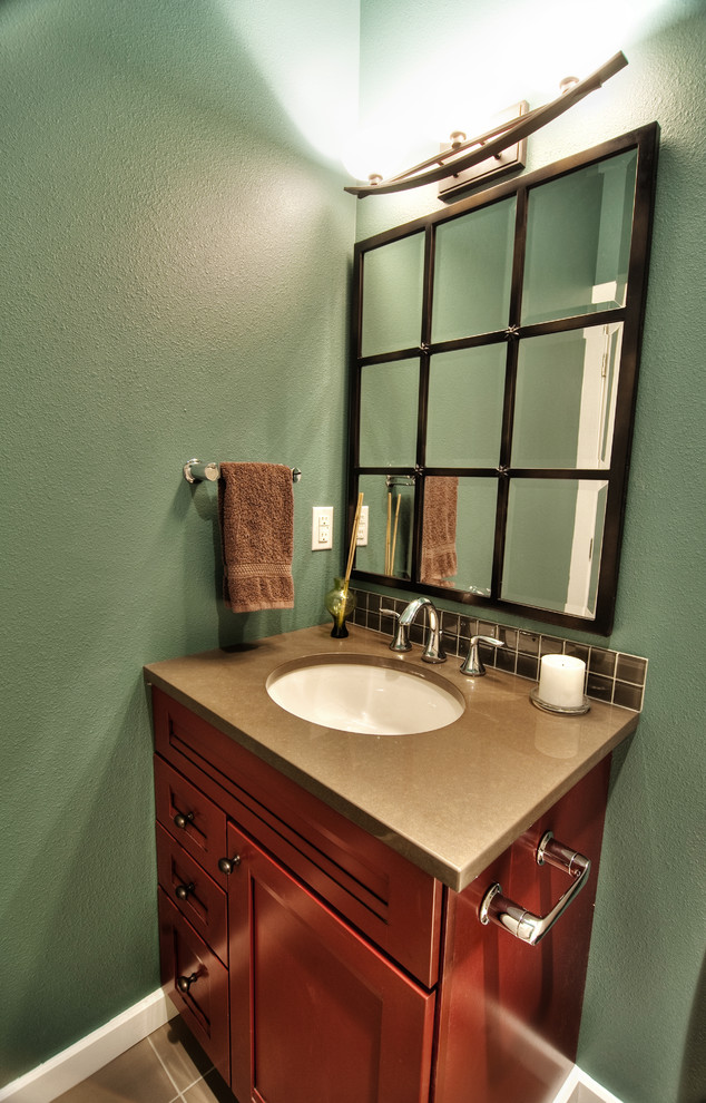 Esempio di una stanza da bagno design con lavabo sottopiano, ante con riquadro incassato, ante in legno scuro, top in superficie solida, piastrelle nere, piastrelle in ceramica, pareti verdi e pavimento con piastrelle in ceramica