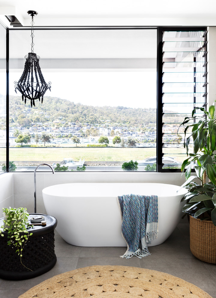 Идея дизайна: главная ванная комната в современном стиле с отдельно стоящей ванной, серой плиткой, керамогранитной плиткой, серыми стенами, полом из керамогранита и серым полом