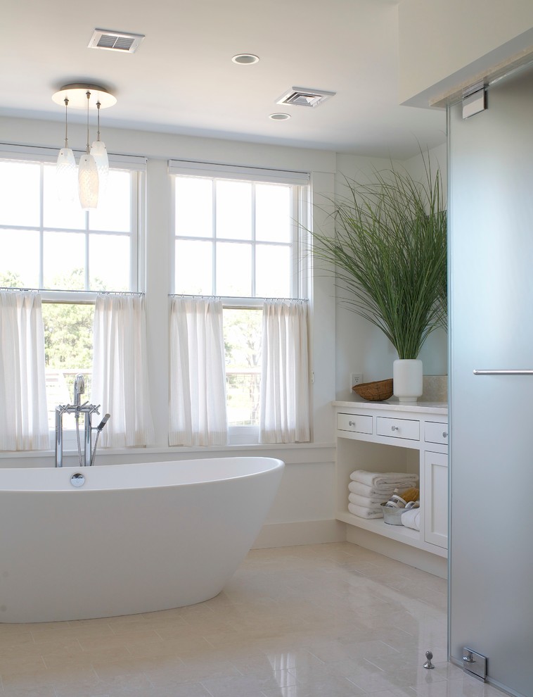 Medium sized beach style ensuite bathroom in Boston with a submerged sink, flat-panel cabinets, white cabinets, marble worktops, a built-in shower, a one-piece toilet, beige tiles, stone tiles, white walls, marble flooring and beige floors.