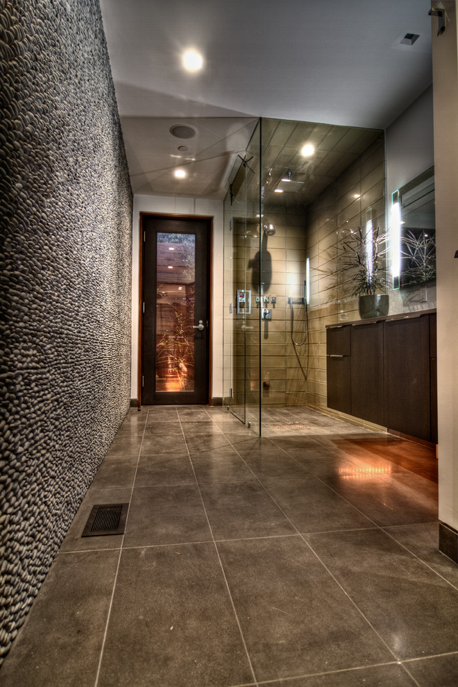 Example of a large 1960s master gray tile and pebble tile black floor corner shower design in Los Angeles with flat-panel cabinets, dark wood cabinets, beige walls and a hinged shower door
