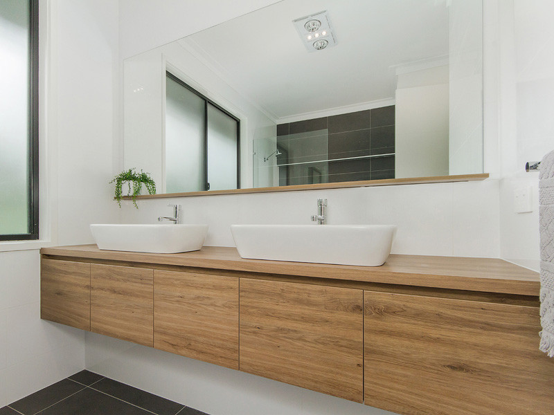 Свежая идея для дизайна: ванная комната в современном стиле с фасадами цвета дерева среднего тона, открытым душем, белой плиткой, керамической плиткой, настольной раковиной и столешницей из ламината - отличное фото интерьера