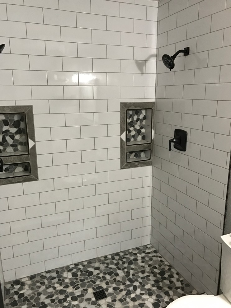 Bild på ett vintage badrum, med luckor med upphöjd panel, vita skåp, en dusch i en alkov, grå kakel, vit kakel, kakel i småsten, grå väggar, klinkergolv i porslin, ett undermonterad handfat och marmorbänkskiva
