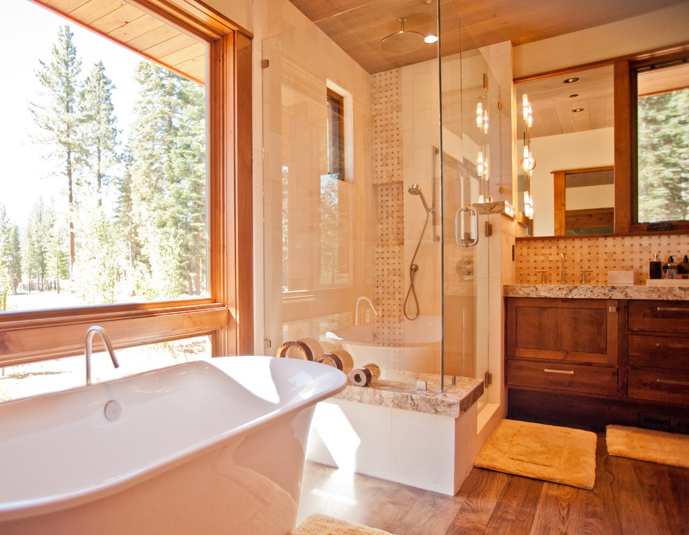 Bild på ett stort rustikt en-suite badrum, med ett undermonterad handfat, skåp i mellenmörkt trä, beige kakel, beige väggar, mellanmörkt trägolv, luckor med profilerade fronter, ett fristående badkar, en dusch i en alkov, keramikplattor, granitbänkskiva, brunt golv och dusch med gångjärnsdörr