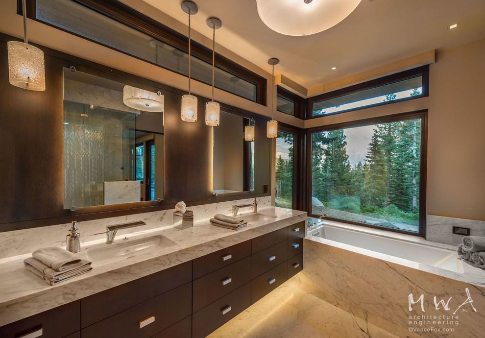 Photo of a large contemporary ensuite bathroom in Other with flat-panel cabinets, dark wood cabinets, a submerged bath, beige walls, a submerged sink, marble flooring, marble worktops, beige floors and beige worktops.