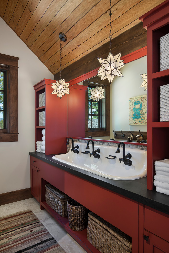 Cette image montre une grande salle de bain chalet pour enfant avec un placard à porte plane, des portes de placard rouges, un carrelage beige, un plan de toilette en granite, un mur blanc et une grande vasque.
