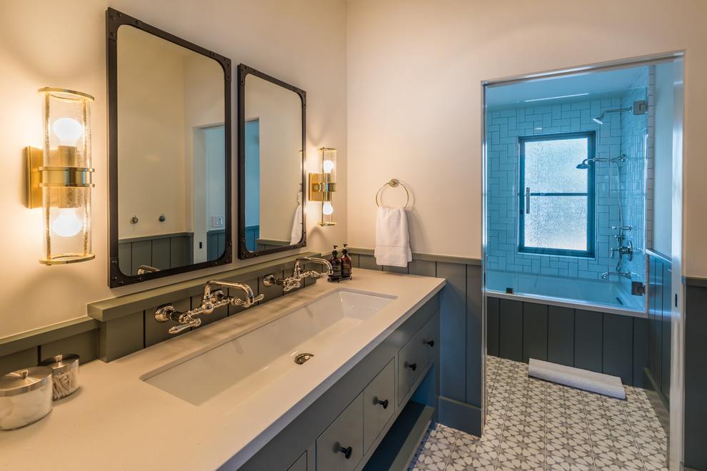 Inspiration for a mid-sized transitional gray tile and subway tile ceramic tile and multicolored floor tub/shower combo remodel in Sacramento with flat-panel cabinets, gray cabinets, an undermount tub, a one-piece toilet, white walls, a trough sink, quartz countertops and a hinged shower door