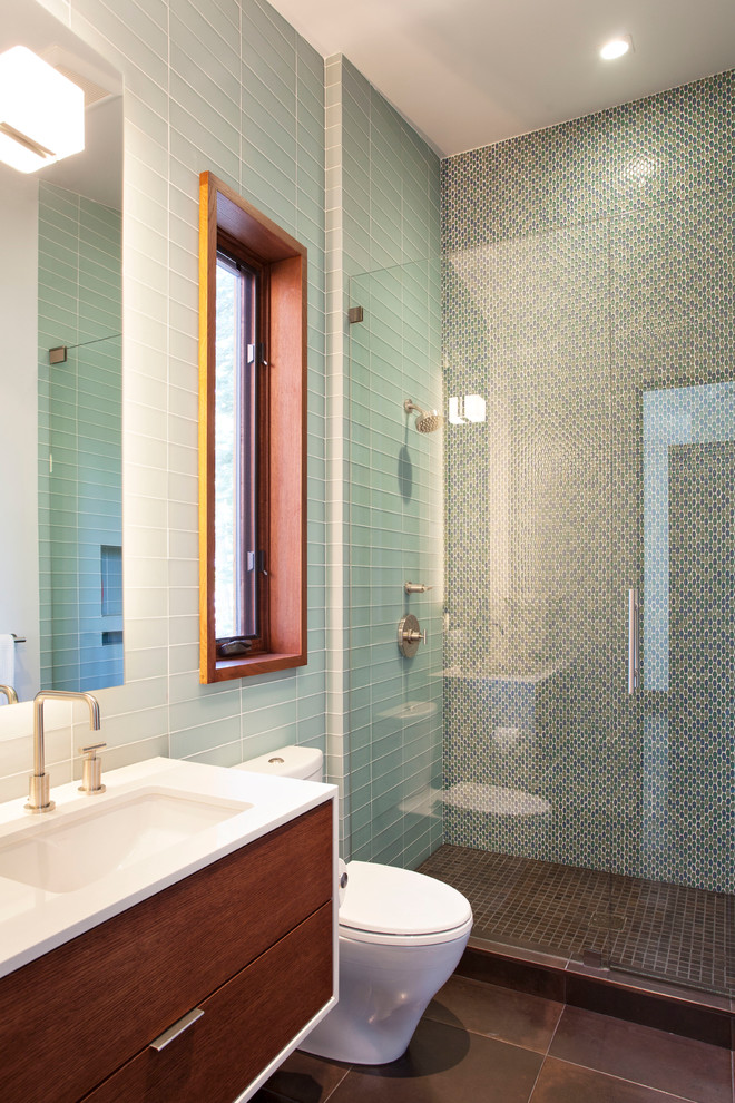 Inspiration pour une douche en alcôve design en bois foncé avec un lavabo encastré, un placard à porte plane, WC séparés, un carrelage bleu et un carrelage en pâte de verre.