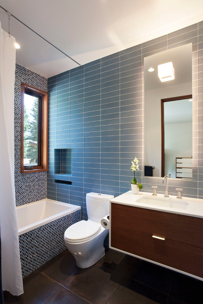 Источник вдохновения для домашнего уюта: ванная комната в современном стиле с врезной раковиной, плоскими фасадами, темными деревянными фасадами, ванной в нише, душем над ванной, раздельным унитазом и серой плиткой