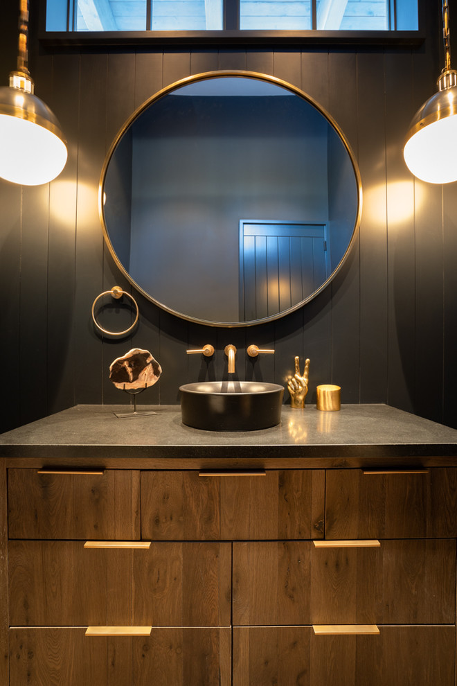 Small rural ensuite bathroom in Other with flat-panel cabinets, distressed cabinets, a one-piece toilet, black walls, light hardwood flooring, a vessel sink, engineered stone worktops and black worktops.