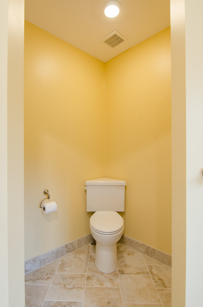 Стильный дизайн: большой туалет в современном стиле с фасадами с утопленной филенкой, фасадами цвета дерева среднего тона, столешницей из гранита, бежевой плиткой, керамогранитной плиткой, врезной раковиной, желтыми стенами и полом из керамогранита - последний тренд