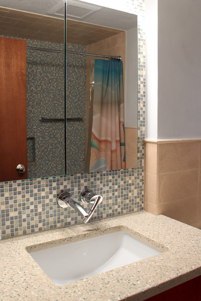 ボストンにある高級な小さなモダンスタイルのおしゃれなマスターバスルーム (アンダーカウンター洗面器、フラットパネル扉のキャビネット、中間色木目調キャビネット、再生グラスカウンター、ドロップイン型浴槽、シャワー付き浴槽	、一体型トイレ	、青いタイル、モザイクタイル、白い壁、大理石の床) の写真