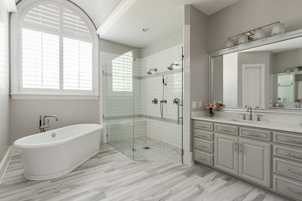 Inspiration for a large traditional ensuite bathroom in Charlotte with grey cabinets, a freestanding bath, a built-in shower, grey tiles, terracotta tiles, grey walls, porcelain flooring, a submerged sink, engineered stone worktops, grey floors, a hinged door and grey worktops.