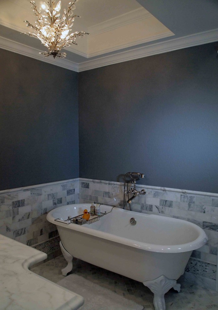 Imagen de cuarto de baño bohemio con lavabo integrado, armarios tipo mueble, puertas de armario con efecto envejecido, encimera de granito, bañera con patas, paredes grises y suelo de baldosas de cerámica