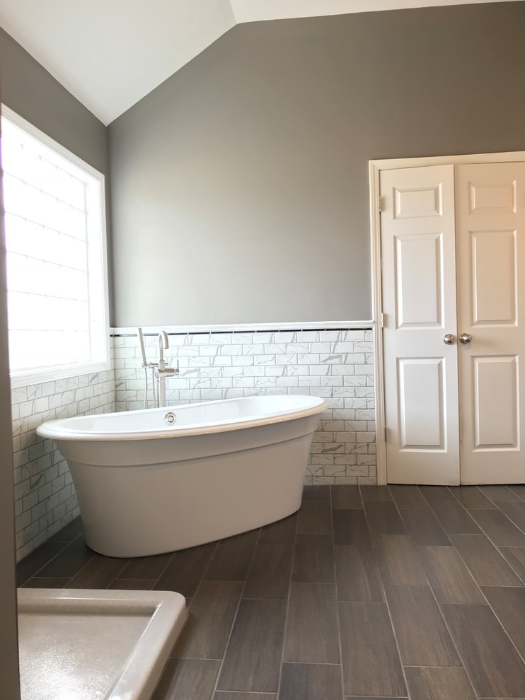 Inspiration for a medium sized traditional ensuite bathroom in Kansas City with grey cabinets, a freestanding bath, a corner shower, a two-piece toilet, grey tiles, porcelain tiles, grey walls, ceramic flooring, a submerged sink, engineered stone worktops and brown floors.
