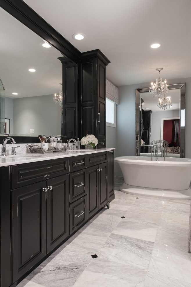 Inredning av ett klassiskt mellanstort en-suite badrum, med ett undermonterad handfat, luckor med upphöjd panel, svarta skåp, marmorbänkskiva, ett fristående badkar, grå väggar och marmorgolv
