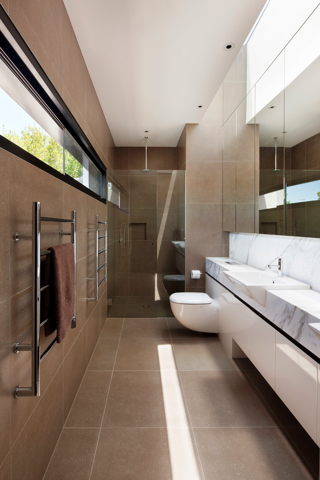 На фото: узкая и длинная ванная комната в стиле модернизм с душем в нише с