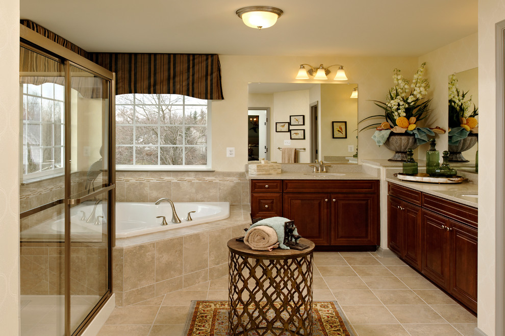 Foto de cuarto de baño principal y rectangular clásico con lavabo bajoencimera, bañera esquinera, ducha empotrada, puertas de armario de madera oscura, baldosas y/o azulejos beige y paredes beige