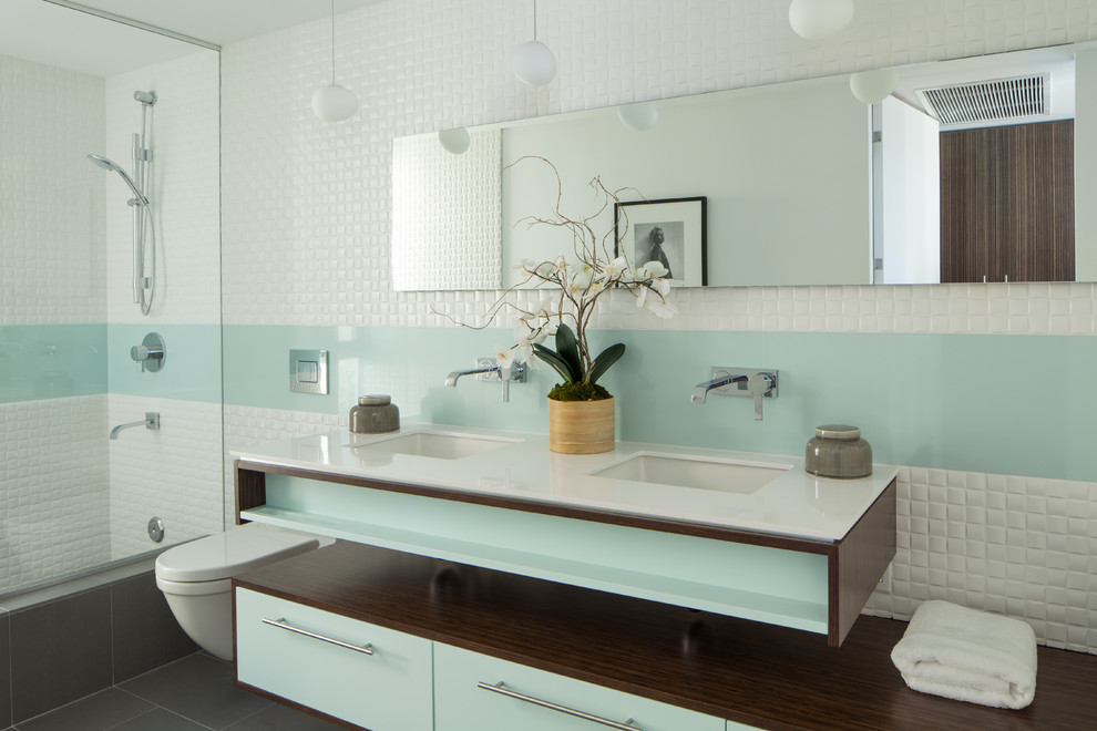 Idee per una stanza da bagno design con lavabo sottopiano, ante lisce, WC sospeso e piastrelle bianche