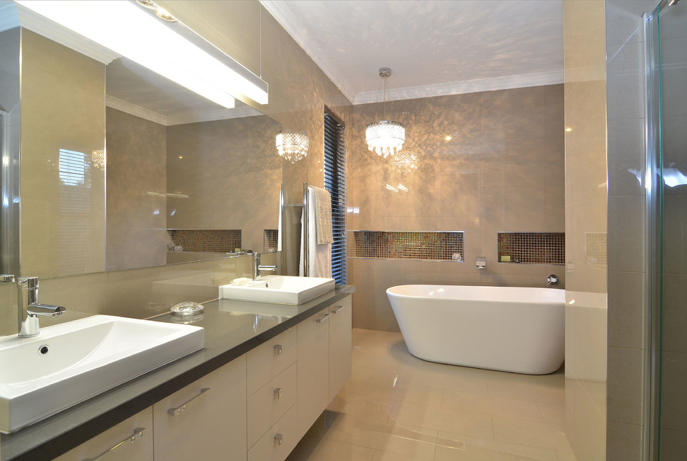 This is an example of a medium sized contemporary ensuite bathroom in Sydney with beige cabinets, engineered stone worktops, a freestanding bath, an alcove shower, a one-piece toilet, multi-coloured tiles, porcelain tiles, beige walls and porcelain flooring.