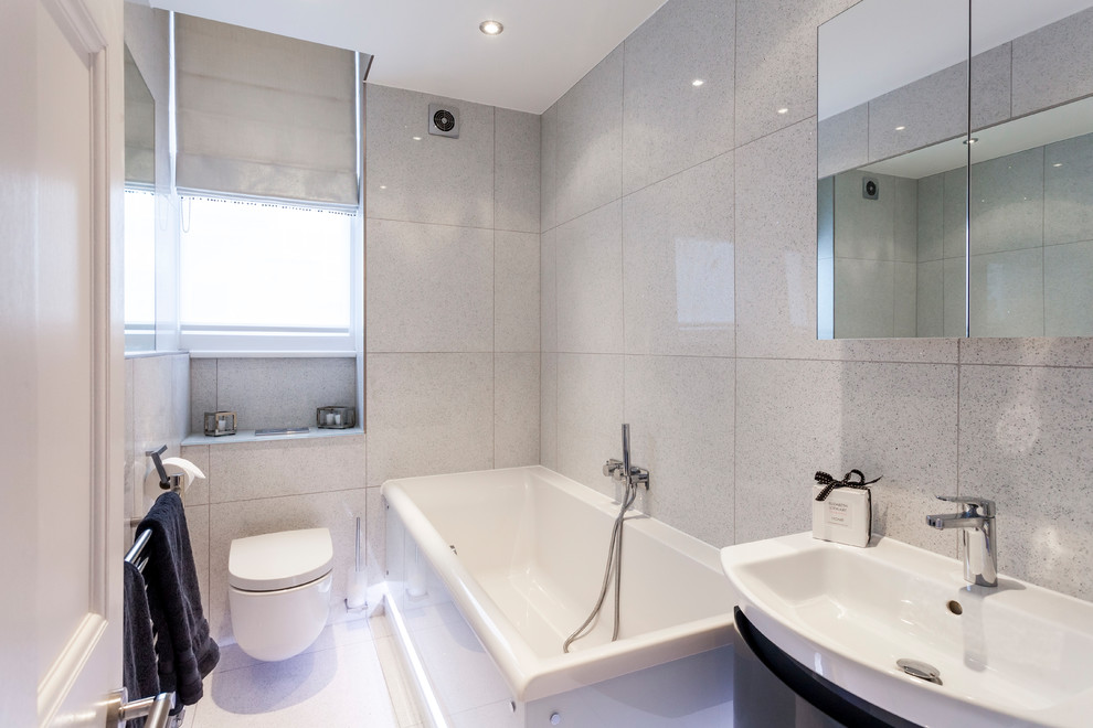 Источник вдохновения для домашнего уюта: главная ванная комната в современном стиле с черными фасадами, накладной ванной, душем над ванной, инсталляцией, серой плиткой, серыми стенами, подвесной раковиной и белым полом
