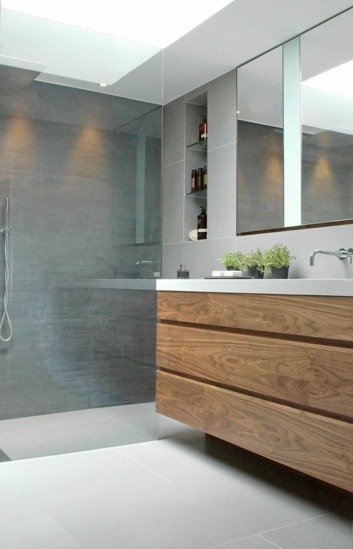 This is an example of a medium sized contemporary bathroom in London with a trough sink, flat-panel cabinets, medium wood cabinets, granite worktops, a walk-in shower, grey tiles and grey walls.