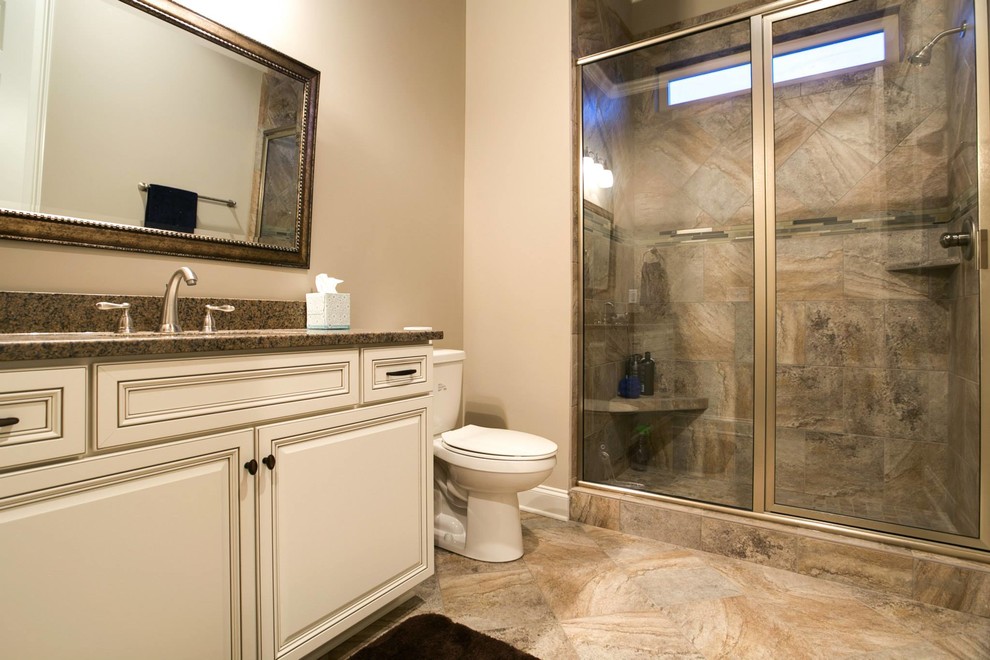Exempel på ett stort modernt en-suite badrum, med ett nedsänkt handfat, luckor med upphöjd panel, vita skåp, granitbänkskiva, en dusch i en alkov, en toalettstol med hel cisternkåpa, beige kakel, keramikplattor, klinkergolv i keramik och beige väggar