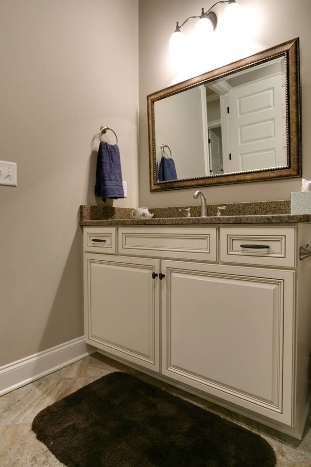 Inspiration for a medium sized contemporary ensuite bathroom in Nashville with a built-in sink, raised-panel cabinets, white cabinets, granite worktops, an alcove shower, a one-piece toilet, beige tiles, ceramic tiles, ceramic flooring and beige walls.