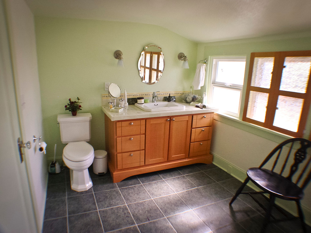 Exemple d'une salle de bain principale chic en bois brun avec un placard en trompe-l'oeil, un plan de toilette en carrelage, un carrelage vert, des carreaux de céramique, un lavabo posé, une douche d'angle, WC séparés, un mur vert et un sol en carrelage de porcelaine.