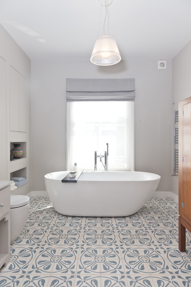 Diseño de cuarto de baño principal tradicional renovado con bañera exenta y paredes grises