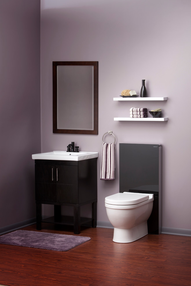 Modelo de cuarto de baño tradicional renovado pequeño con lavabo encastrado, encimera de mármol, sanitario de una pieza, paredes púrpuras, suelo de madera oscura, aseo y ducha, armarios tipo mueble y puertas de armario negras