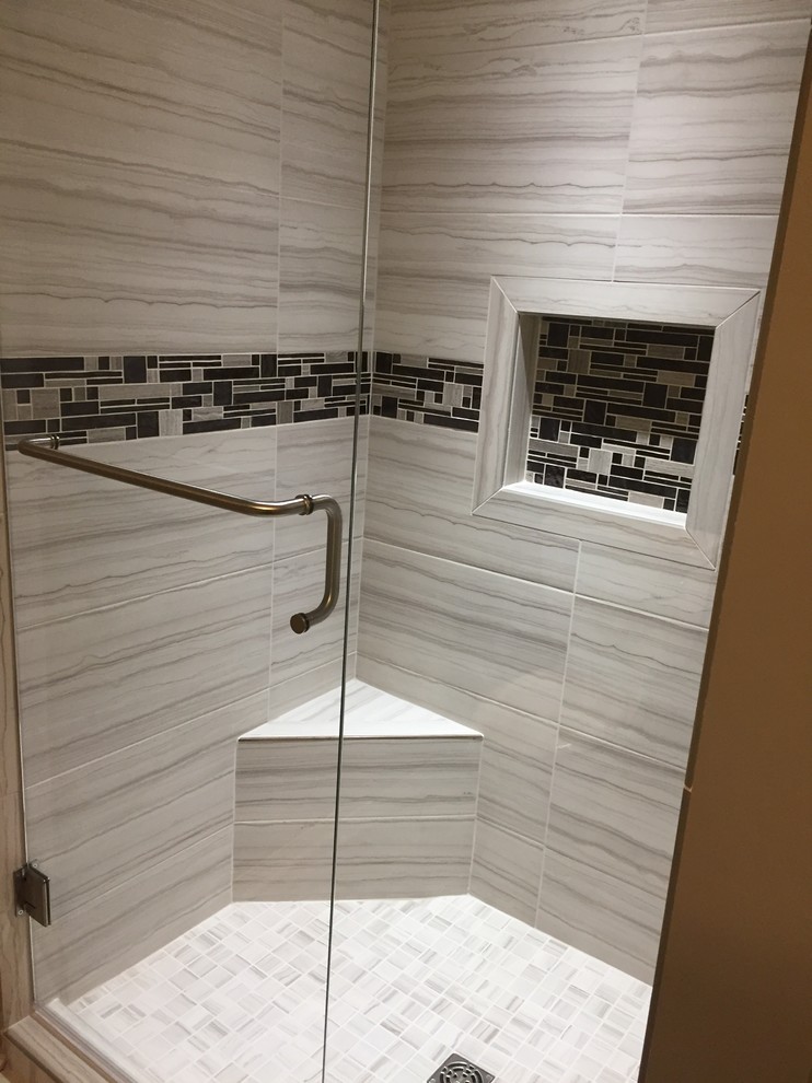 Klassisk inredning av ett litet grå grått badrum med dusch, med luckor med upphöjd panel, beige skåp, en toalettstol med separat cisternkåpa, mosaik, klinkergolv i porslin, ett undermonterad handfat, bänkskiva i kvarts, dusch med gångjärnsdörr, en dusch i en alkov, grå kakel, grå väggar och grått golv