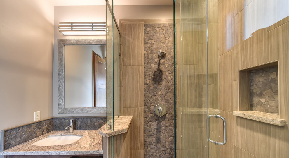 Modelo de cuarto de baño principal moderno con puertas de armario de madera en tonos medios, bañera encastrada, baldosas y/o azulejos grises, baldosas y/o azulejos de cerámica, suelo de baldosas de cerámica, lavabo encastrado y encimera de granito