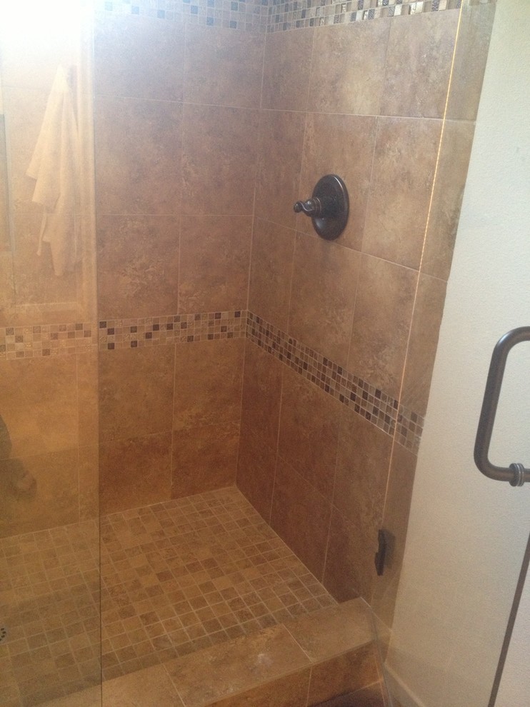 Photo of a medium sized mediterranean bathroom in Orange County with shaker cabinets, brown cabinets, a walk-in shower, a one-piece toilet, brown tiles, stone tiles, white walls, porcelain flooring and quartz worktops.