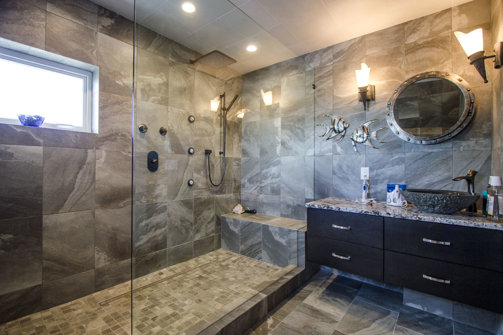 This is an example of a large contemporary ensuite bathroom in Vancouver with flat-panel cabinets, dark wood cabinets, a walk-in shower, a wall mounted toilet, grey tiles, porcelain tiles, porcelain flooring, a vessel sink and granite worktops.