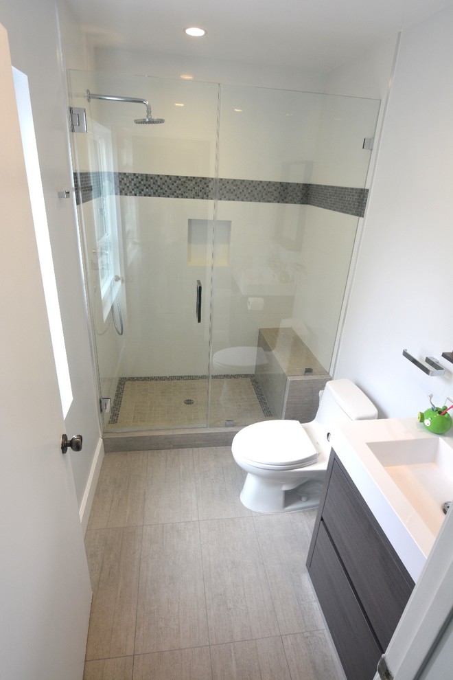 Photo of a small modern shower room bathroom in Los Angeles with beaded cabinets, dark wood cabinets, a walk-in shower, a one-piece toilet, multi-coloured tiles, white walls, light hardwood flooring, a built-in sink and quartz worktops.