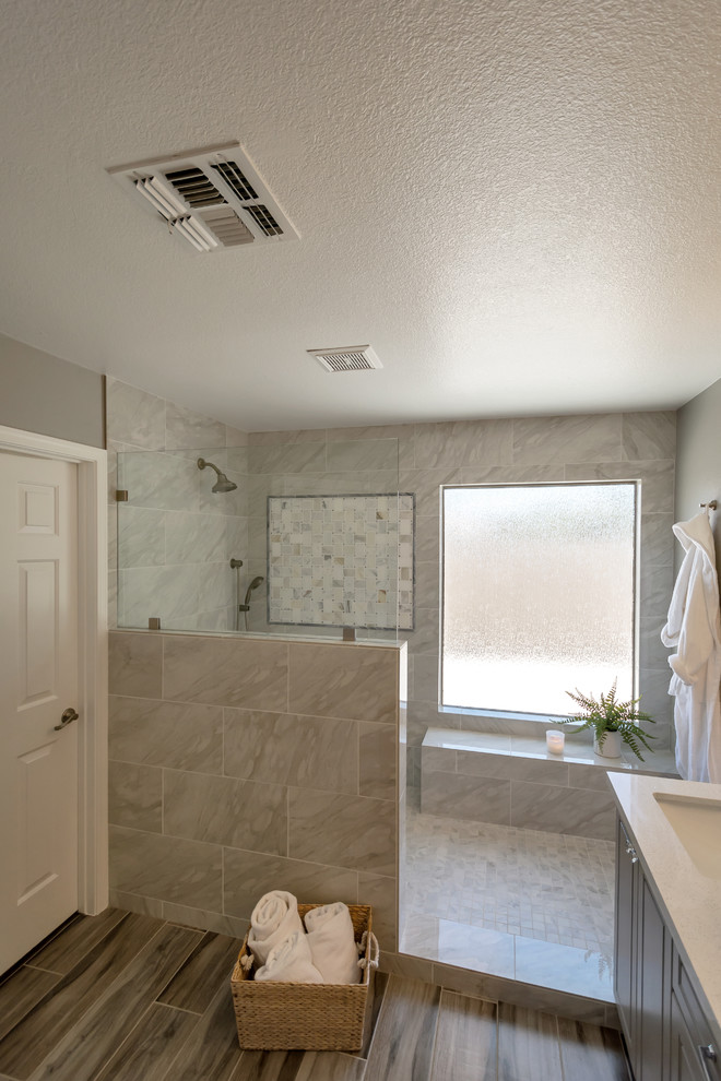 Пример оригинального дизайна: главная ванная комната среднего размера в стиле неоклассика (современная классика) с фасадами с выступающей филенкой, серыми фасадами, открытым душем, серой плиткой, керамогранитной плиткой, серыми стенами, полом из керамогранита, накладной раковиной, столешницей из искусственного кварца, серым полом, открытым душем и белой столешницей