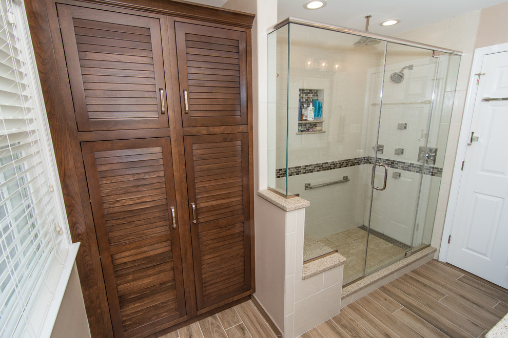 Mid-sized transitional master beige tile and porcelain tile porcelain tile and brown floor alcove shower photo in Philadelphia with louvered cabinets, brown cabinets, a two-piece toilet, beige walls, an undermount sink, quartz countertops and a hinged shower door