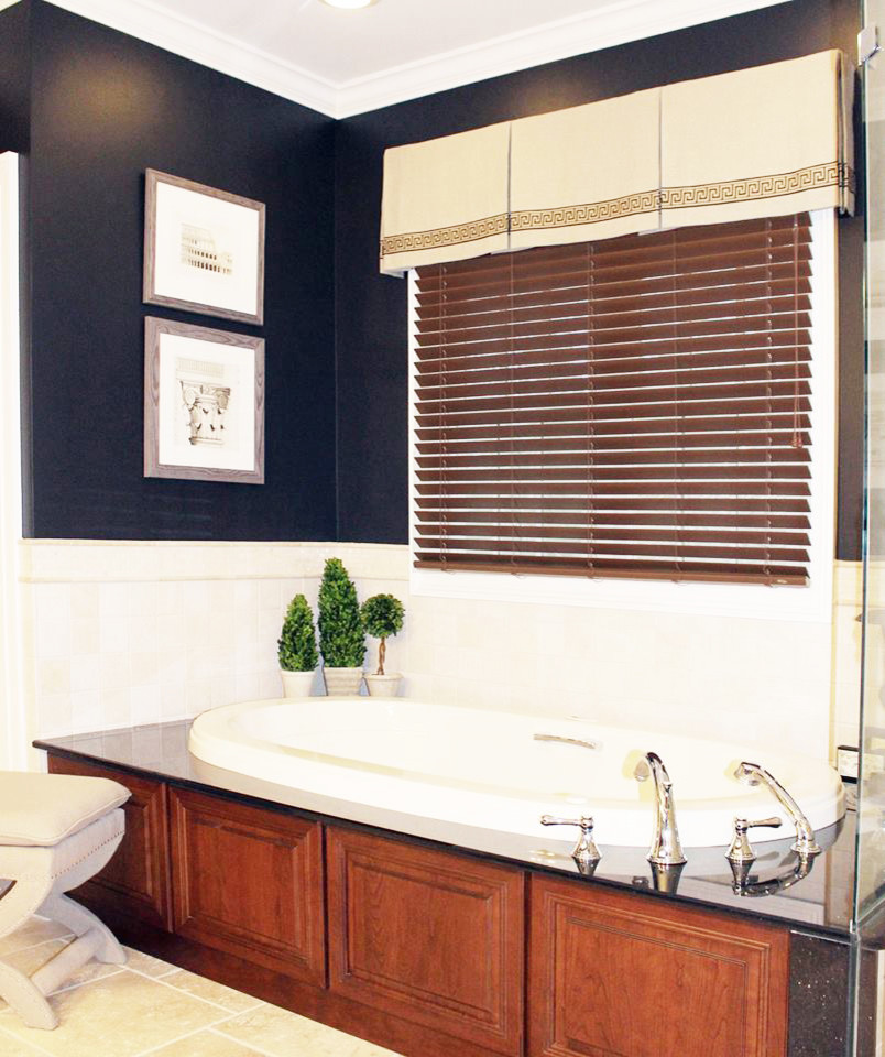 Klassisk inredning av ett mellanstort en-suite badrum, med ett undermonterad handfat, luckor med upphöjd panel, skåp i mellenmörkt trä, granitbänkskiva, ett platsbyggt badkar, en hörndusch, en toalettstol med separat cisternkåpa, beige kakel, stenkakel, svarta väggar och travertin golv