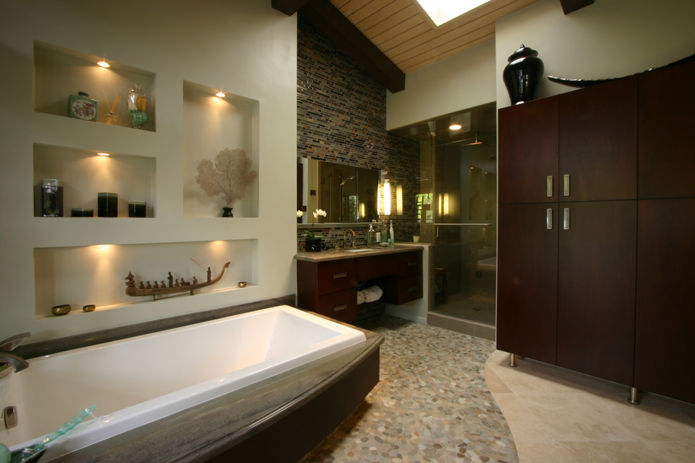 Bathroom - large asian master multicolored tile pebble tile floor bathroom idea in Los Angeles with flat-panel cabinets, dark wood cabinets, a two-piece toilet, beige walls, an undermount sink, granite countertops and a hinged shower door