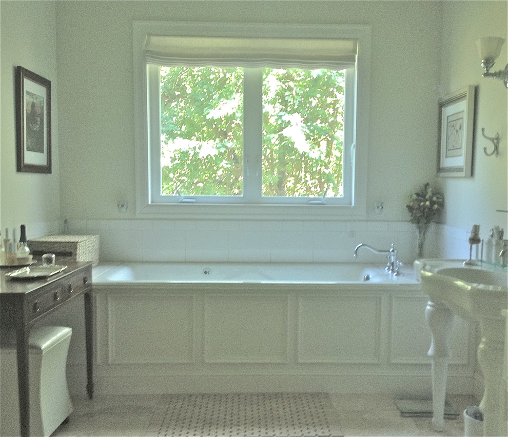 На фото: большая главная ванная комната в классическом стиле с ванной в нише, галечной плиткой, белыми стенами, полом из керамической плитки и раковиной с пьедесталом с