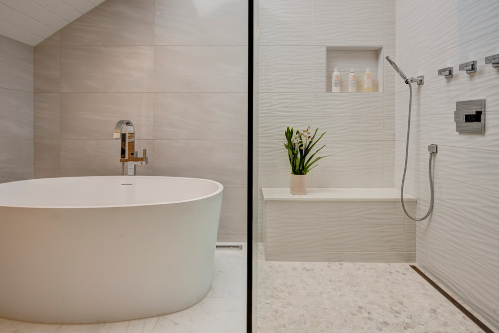 На фото: главная ванная комната среднего размера в современном стиле с плоскими фасадами, светлыми деревянными фасадами, отдельно стоящей ванной, белой плиткой, керамогранитной плиткой и стеклянной столешницей с