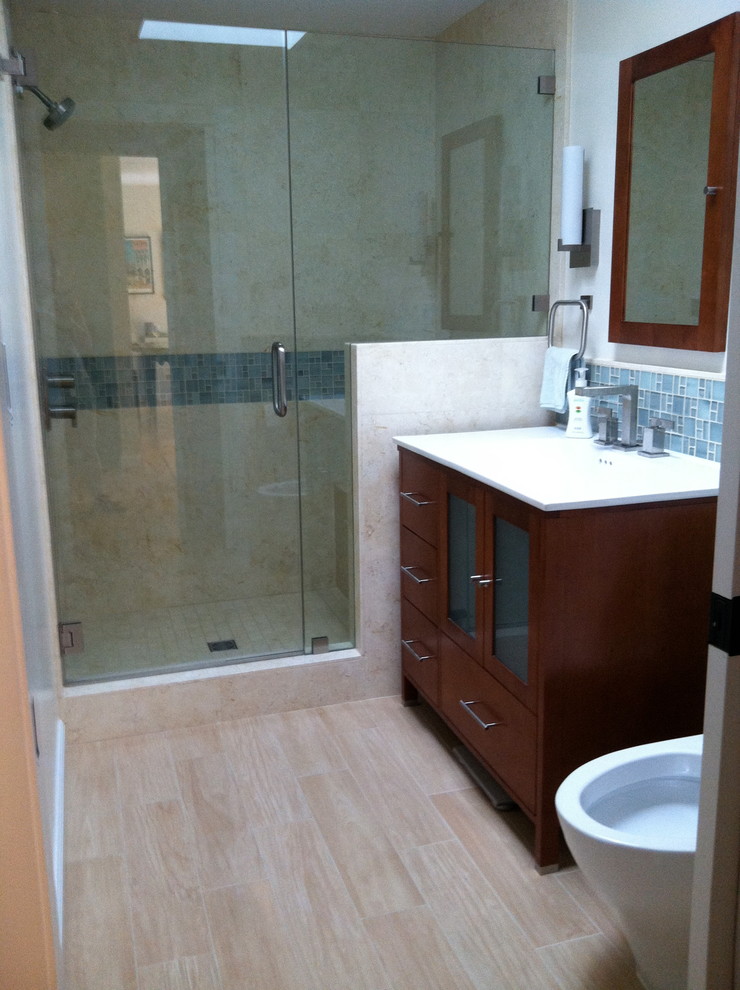 Réalisation d'une salle de bain principale minimaliste en bois foncé de taille moyenne avec un lavabo intégré, un placard à porte plane, une douche ouverte, WC à poser, un carrelage de pierre, un mur blanc et un sol en carrelage de porcelaine.