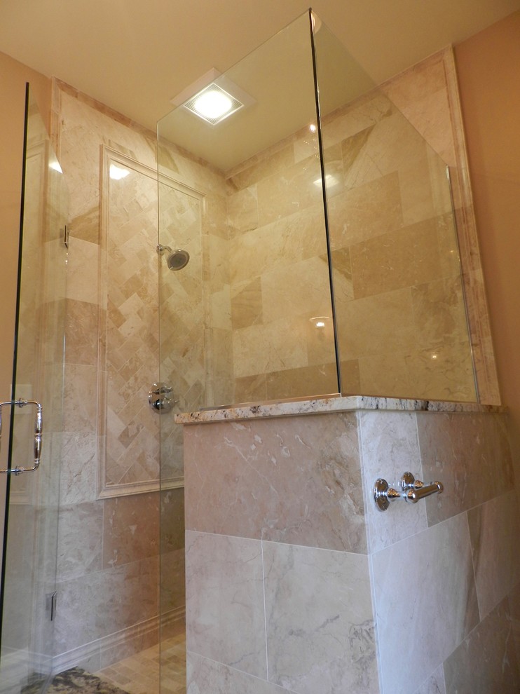 Doorless shower - traditional beige tile and stone tile doorless shower idea in Chicago with an undermount sink, raised-panel cabinets, medium tone wood cabinets, granite countertops and a two-piece toilet