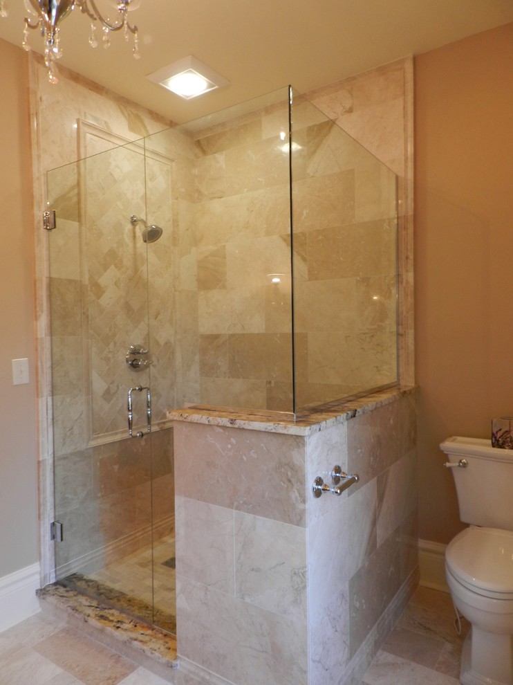 Elegant stone tile and beige tile doorless shower photo in Chicago with raised-panel cabinets, medium tone wood cabinets, granite countertops, a two-piece toilet and an undermount sink