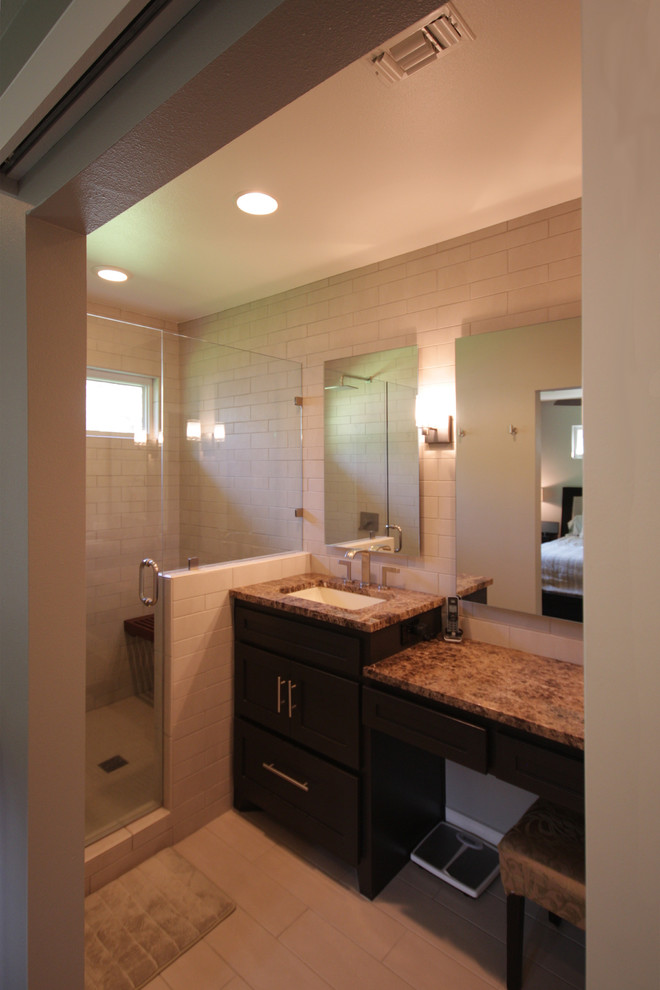 Cette image montre une salle de bain design de taille moyenne avec un lavabo encastré, un placard à porte shaker, des portes de placard marrons, un plan de toilette en granite, un carrelage blanc, un carrelage métro et un mur beige.