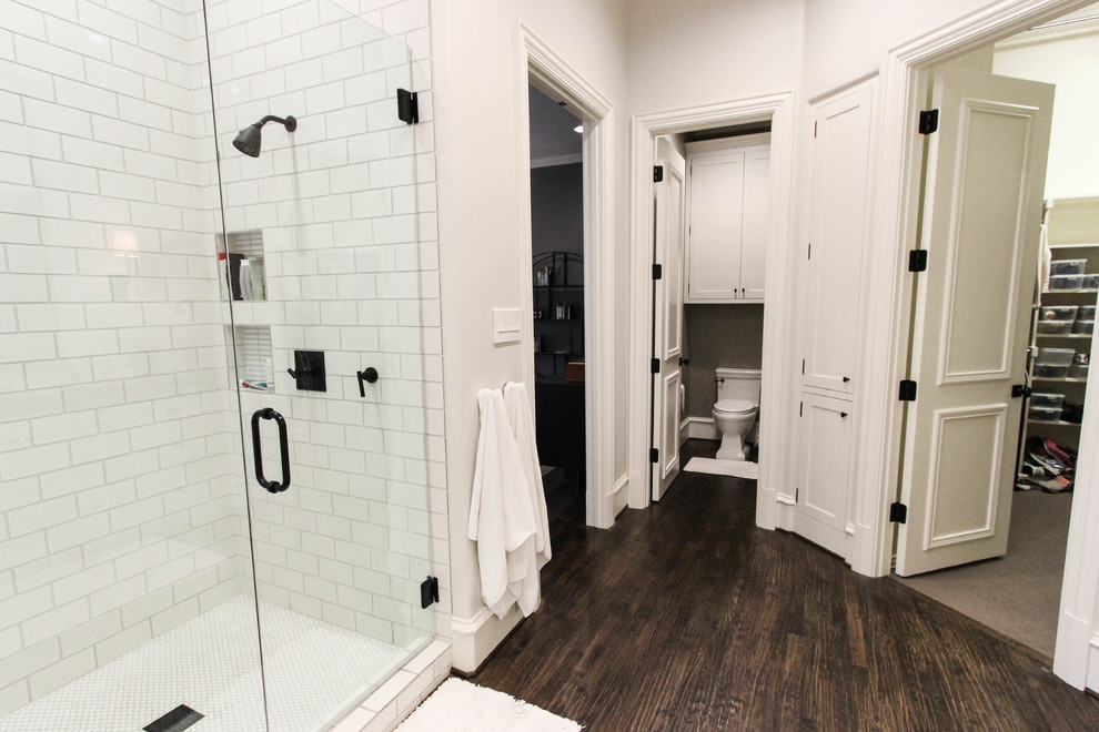 Klassisches Badezimmer En Suite mit Unterbauwaschbecken, weißen Schränken, Einbaubadewanne, weißen Fliesen, Metrofliesen, weißer Wandfarbe und dunklem Holzboden